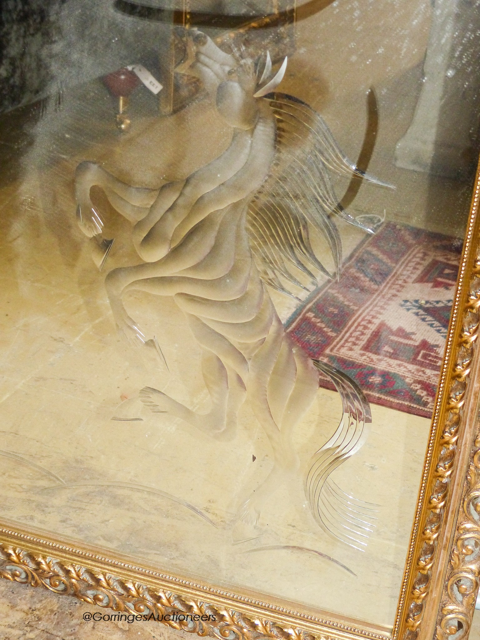 A rectangular gilt wall mirror etched with a stallion, width 120cm, height 90cm